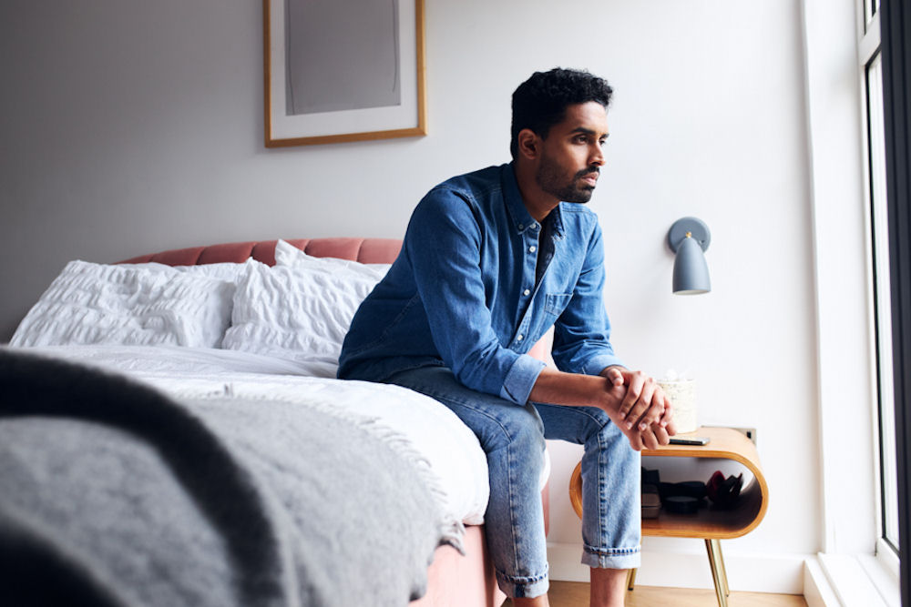 man sitting on bed