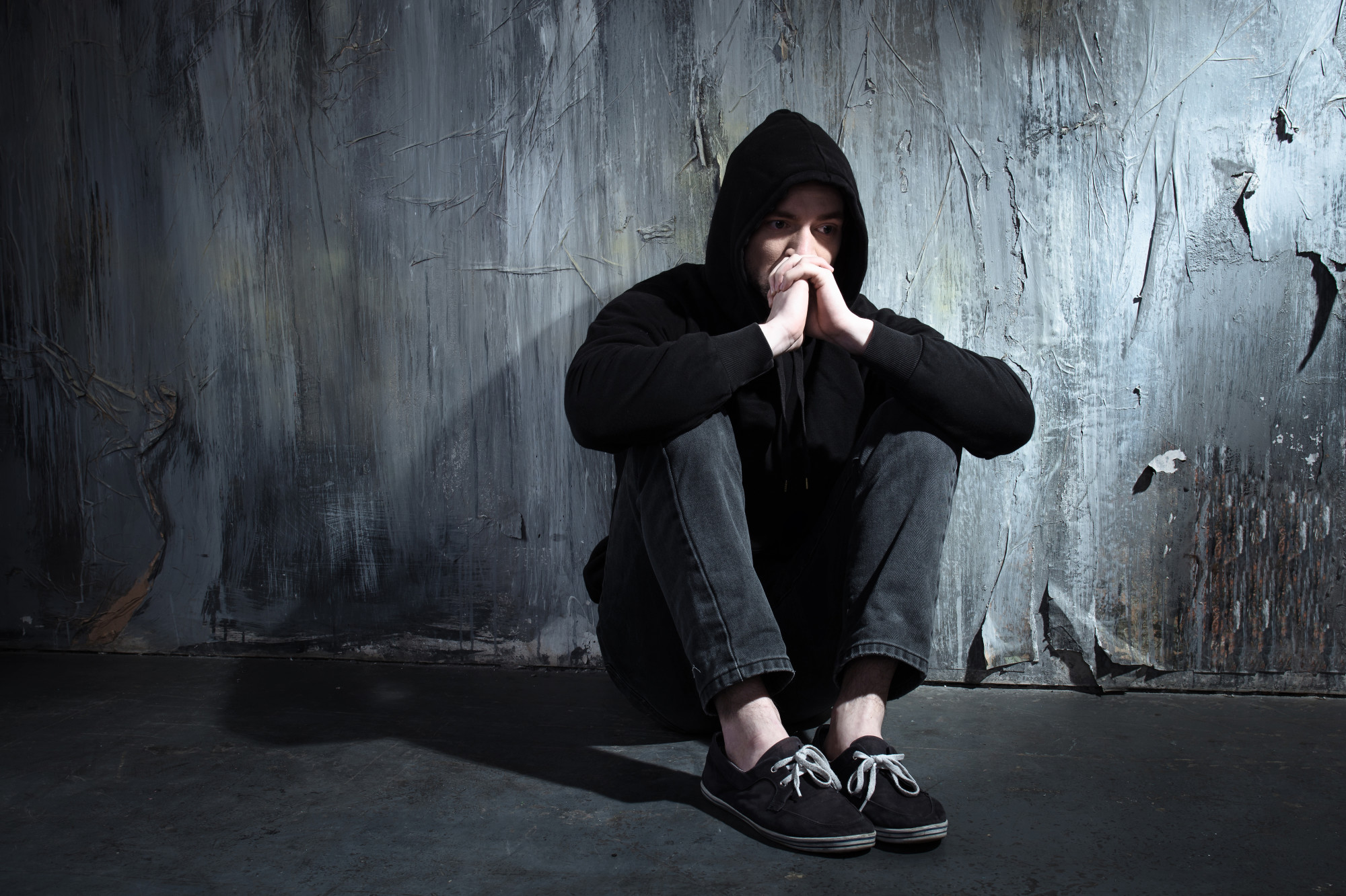 man-sitting-in-the-dark-holding-his-hands