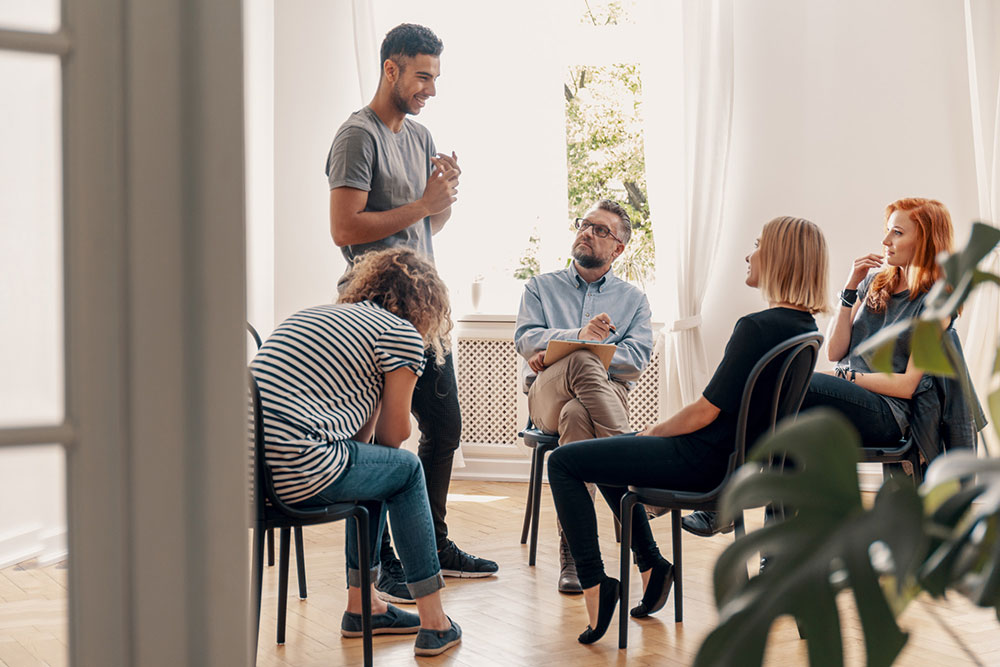 a-man-standing-up-speaking-in-therapy