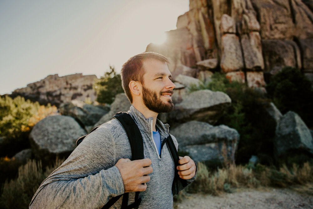 a man holding his backpack hiking