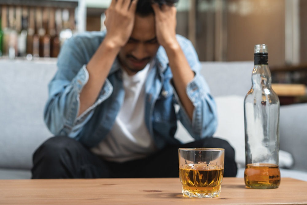 a man with hands on head experiencing dry drunk