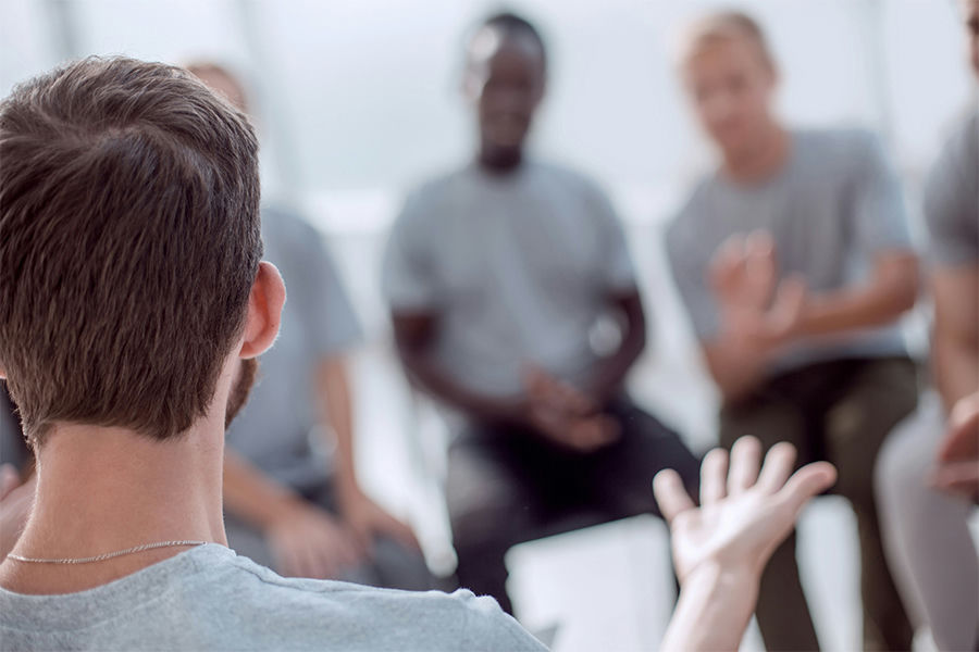 a man speaking in group therapy
