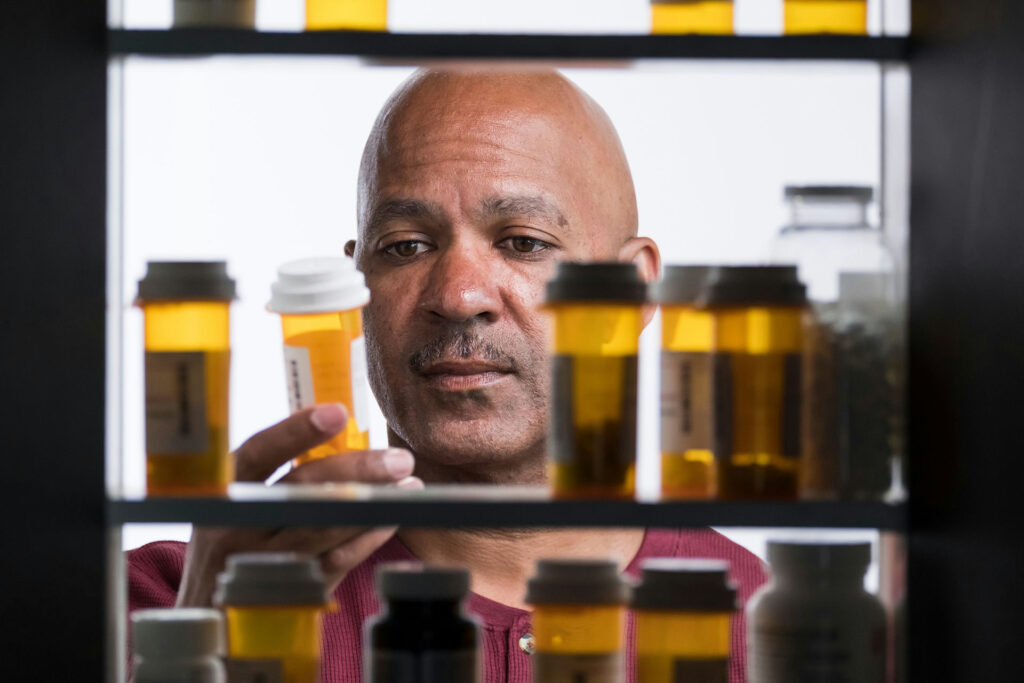 man holding a pill bottle, symbolizing how long benzos stay in your system.