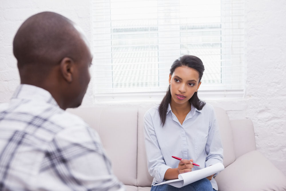 Man sitting with therapist taking notes treatment for addiction and bipolar disorder in wisconsin