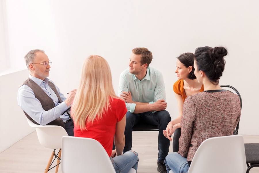 a-group-of-individuals-speaking-to-therapist